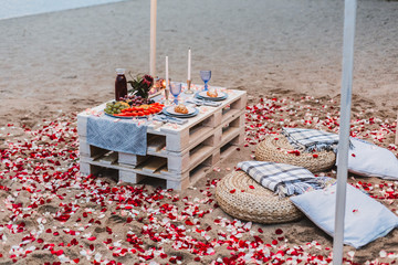 Romantic dinner  at the beach concept. Romantic dinner served for two on the sea beach with candles and wine.