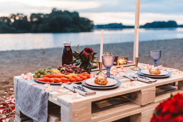 romantic dinner at the beach concept. romantic dinner served for two on the sea beach with candles a