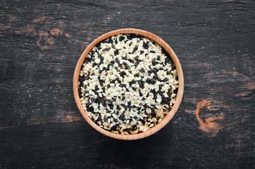 Wall Mural - Sesame. Set of black and white sesame seeds. On a black background. Top view. Free copy space.