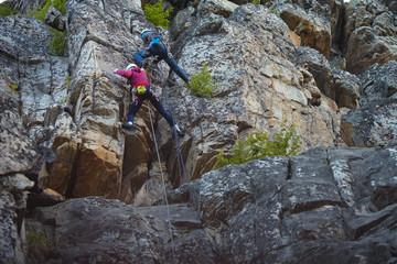 Wall Mural - Two climbers on a rock wall closeup.