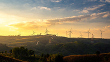 Wind Turbines And Orange Sunset Sky. Beautiful Mountain Landscape With Wind Generators Turbines,Thailand. Renewable Energy Concept. 