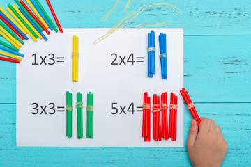 kid doing multiplication equations using counting rods