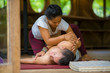 © TheVisualsYouNeed - young beautiful and exotic Asian Indonesian therapist woman giving traditional Thai massage to man relaxed at tropical wellness spa in healthy natural lifestyle