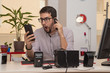 businessman, at the office, with expression gesture when seeing the smartphone