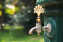 Antique Faucet Tap In A Green Park On A Sunny Day. Close Up.