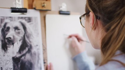 Wall Mural - Female Teenage Artist Sitting At Easel Drawing Picture Of Dog From Photograph In Charcoal