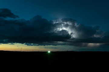 Wall Mural - high based thunderstorm over the plains of north dakota is illuminated by lightning during the twili