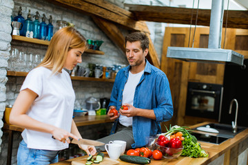 Sticker - Lovely cheerful couple cooking dinner together and having fun at rustic kitchen