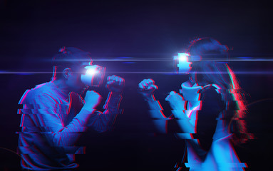 Wall Mural - Couple with virtual reality headset are playing game and fighting. Man vs woman. Image with glitch effect.