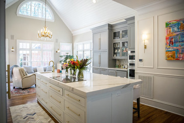 Open Concept Elegant and Spacious Kitchen with Marble Countertops, Chandelier, and Two Toned Cabinets