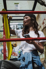 Wall Mural - Young pretty smiling hipster girl with skateboard