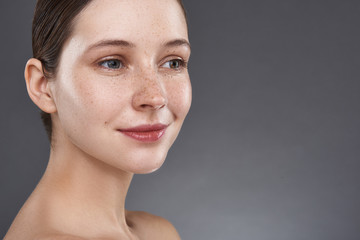 Sticker - Cute smiling girl with freckles standing against gray background