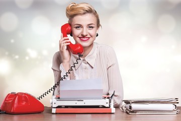 Attractive young woman working on vintage typewriter