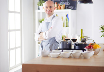 Handsome man is cooking on kitchen and smiling