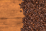 Fototapeta Kuchnia - A coffee beans and wood background.