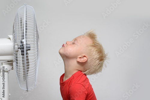 Pretty smiling blond boy in red shirt and closed eyes enjoying the cool air Poster Mural XXL