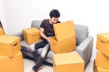 Wall Mural - Happy young man unpacking box and moving into their new home.House moving and real estate concept