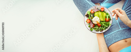 Fotomural Young woman is resting and eating a healthy food after a workout