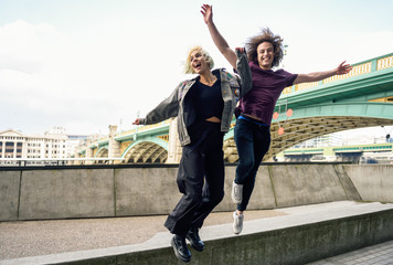 Funny couple junping near the Southwark bridge over River Thames, London