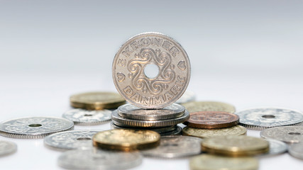 Wall Mural - Five kroner coin standing on a pile of other Danish coins with selective focus. The krone is the official currency of Denmark, Greenland, and the Faroe Islands, introduced on 1 January 1875.