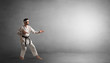 © ra2 studio - Small karate man fighting in an empty grey copy space