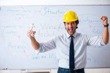 Young male architect in front of the whiteboard 