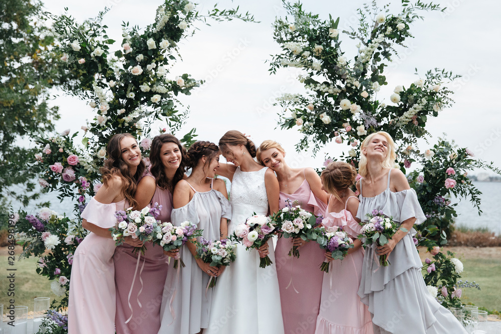 Beautiful elegant slim smiling bridesmaids in delicate pink beige summer dress on the wedding ceremony. - obrazy, fototapety, plakaty 