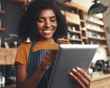 © StratfordProductions - Smiling female cafe owner using digital tablet