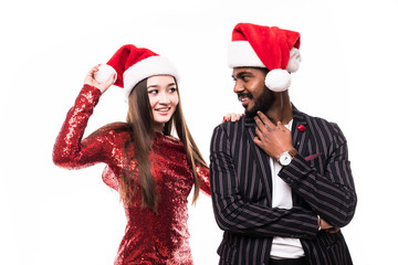 Portrait of a cheerful asian couple in christmas hats looking at camera isolated over white background