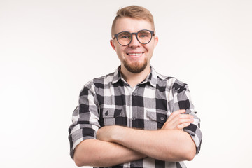 People, nerd and education concept - Smiling handsome student man in plaid shirt, crossed arms, over white background