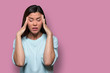 Woman overwhelmed with stress and concern, confusion and doubt, hands to head, on pink background copy space