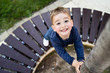 © Miljan Živković - High angle view on small boy holding a tree by the bench at city square want to climb