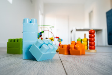 Toys on the floor plastic brick blocks and colorful wood brain teasers