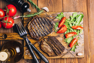 Wall Mural - grilled beef steaks with spices on wooden cutting board