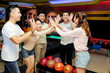 © DragonImages - Friends celebrating victory with in bowling center