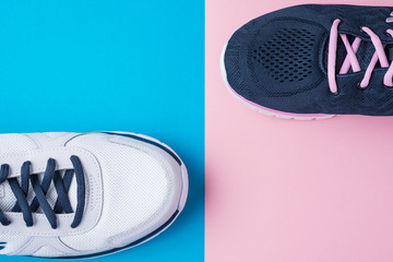 Wall Mural - Male and female sport shoes on a pink and blue background, flat lay top view. Running sneakers on colorful background