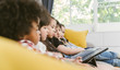 © saksit - group of little children watching film movie cartoon together on digital tablet. Kids playing with tablet with friends at home.