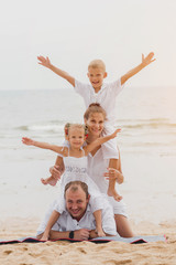 Wall Mural - Happy young family on the sunset at the beach.