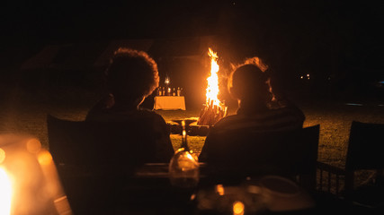 Senior couple traveller sitting in front of a bonfire in camp in Sri Lanka