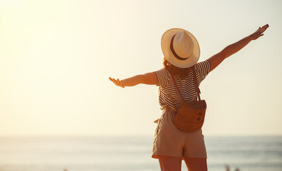 Wall Mural - happy tourist girl with backpack and hat on sea.