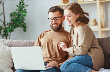 happy couple with laptop computer at home  .