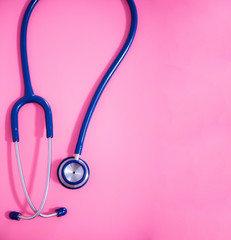 Wall Mural - Top view blue stethoscope on pink background. For check heart or health check up concept