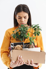 Sticker - Full length portrait of confused young woman dressed in elegant wear holding box with office supplies due to firing