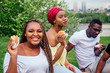 © yurakrasil - happy casual america african people having fun and eating burger outdoors lifestyle,students for a break summer evening cloudy weather in park