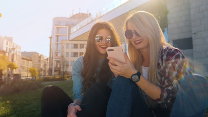 Young pretty woman posing in the street with phone.