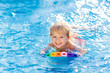 © famveldman - Child learning to swim. Kids in swimming pool.