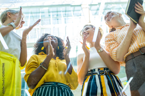 Fotomural Happy group of talented successful young businesswomen, designers clapping in office, low view