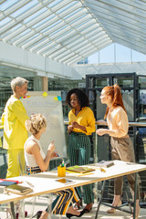 Wall Mural - serious girls in bright colorful casual wear discussing a topic. fashion designers brainstorming in the office room