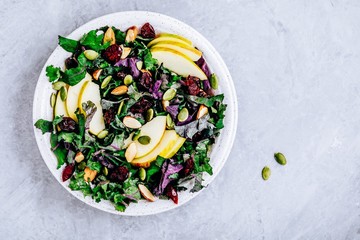 Apple Cranberry Kale Salad bowl with dry cranberries, almonds and pumpkin seeds.