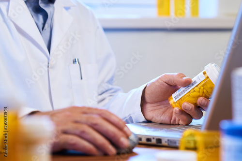Fotografía Doctor writing out prescription on a laptop